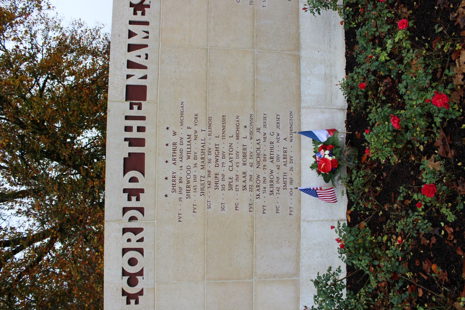 A bronze rosette is placed next to the name of Robert Skaar on the Walls of the Missing