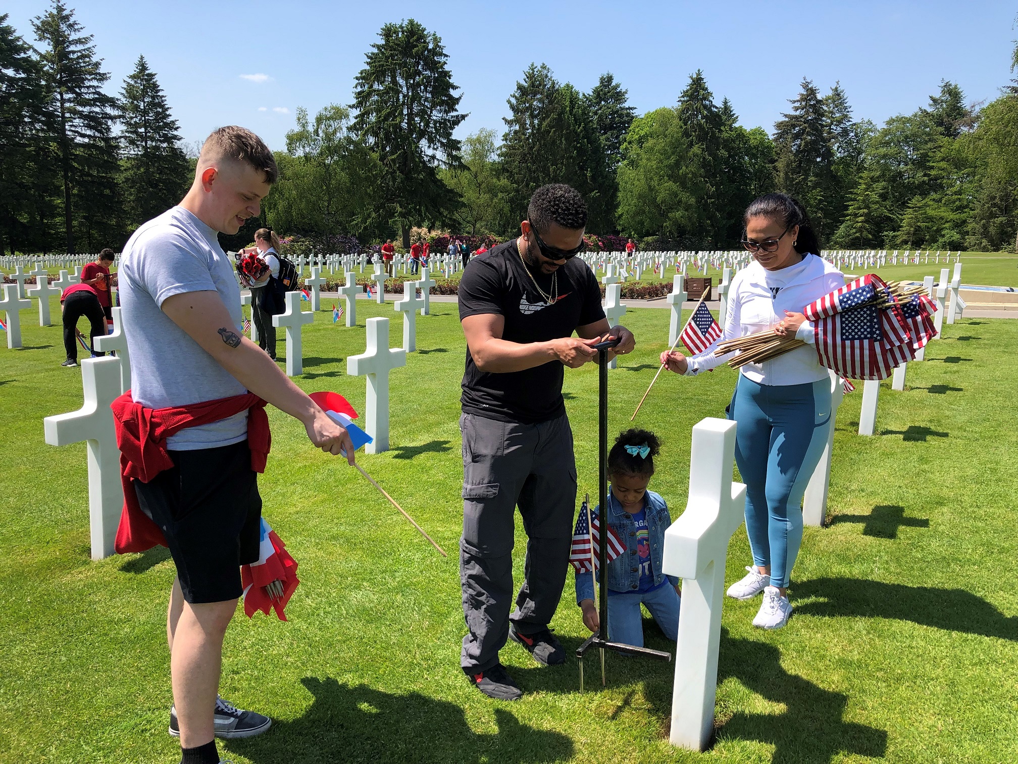 Volunteers from local U.S. military bases place flags at Luxembourg American Cemetery ahead of Memorial Day ceremony.