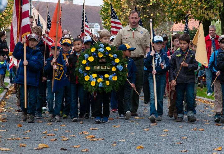 Cub Scouts march in with flags and wreath during the ceremony. 