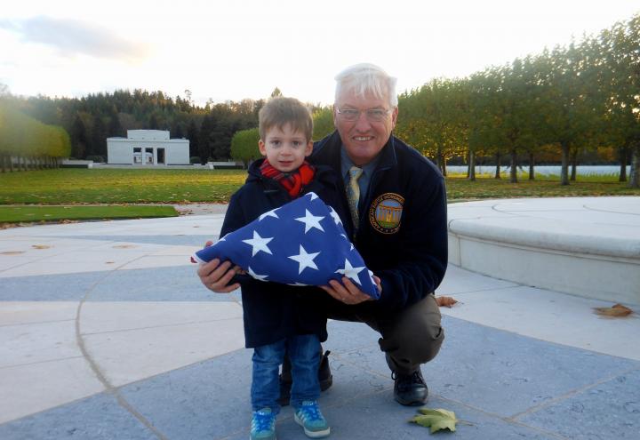 Aaron Howson and Superintendent Anderson stand with folded flag. 