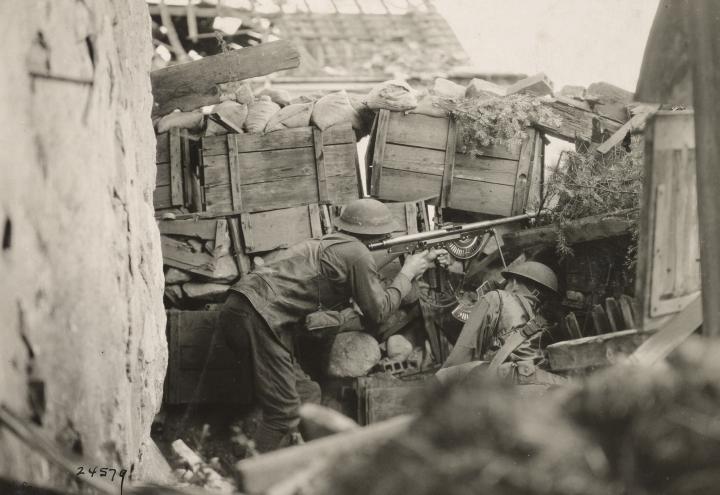 Historic photo shows soldiers firing a rifle. 