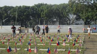 Volunteers place an American and Filipino flag at every grave site. 