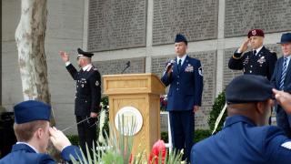 An airman sings the national anthem from the podium area.