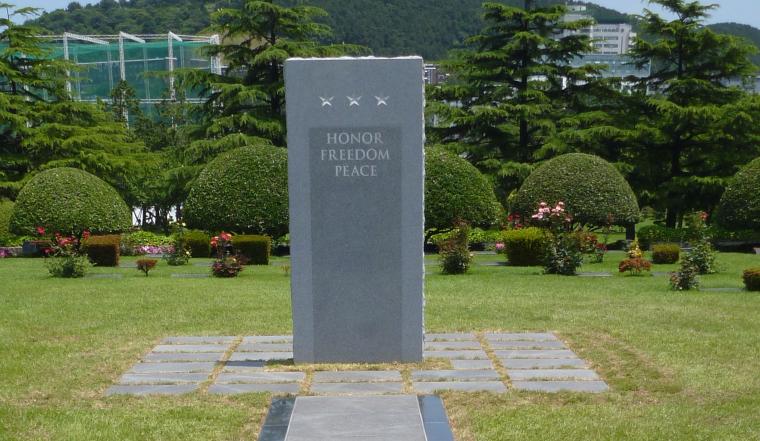 The words honor, freedom, and peace are inscribed on gray granite slab.