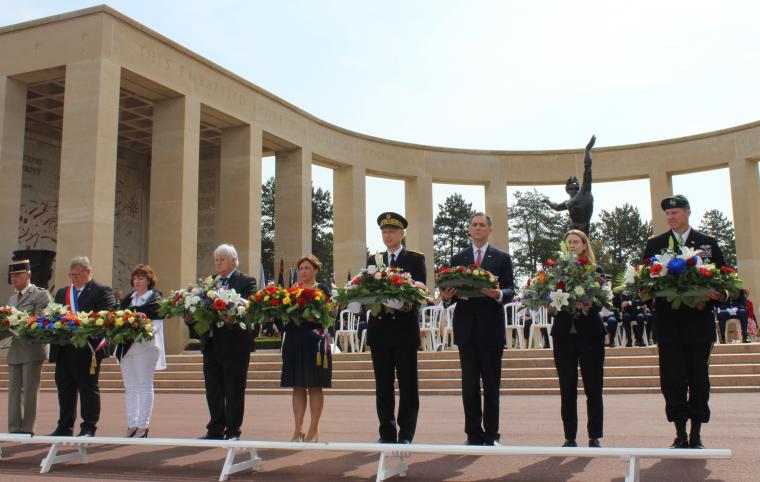 Men and women prepare to lay floral wreaths.
