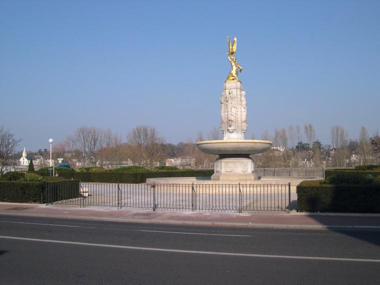 The Tours American Monument, a white stone fountain with a gold statue of an American Indian holding an eagle.